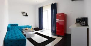 a living room with a blue couch and a red refrigerator at Solemar Boutique in Eforie Sud