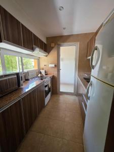 a kitchen with wooden cabinets and a white refrigerator at Caseros Salta in Salta