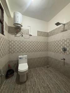 a bathroom with a white toilet in a room at The Pine View in Kasol