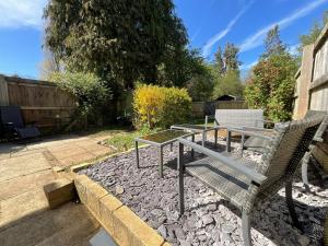 a patio with two chairs and a table on a rock at Cotswolds Vista Cirencester - Relaxed 5 Guest Home - 2 Bathroom, Parking, Garden in Cirencester