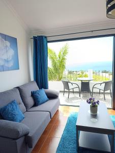 a living room with a couch and a view of the ocean at Casa de Campo in Caniço