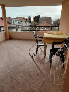 a table and a chair on a balcony at Студиа Мансарда Ненови in Pomorie