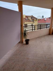 a balcony with a white wall and a potted plant at Студиа Мансарда Ненови in Pomorie