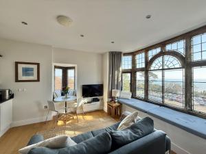 a living room with a couch and a large window at 4 Coram Tower in Lyme Regis