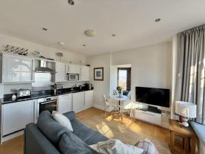 a living room with a couch and a kitchen at 4 Coram Tower in Lyme Regis