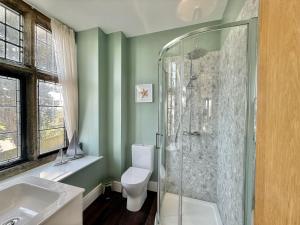a bathroom with a toilet and a glass shower at 4 Coram Tower in Lyme Regis +19 photos