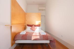 a bedroom with a bed with a wooden headboard at Porto Lounge Hostel & Guesthouse by Host Wise in Porto