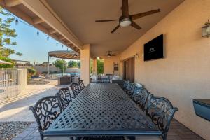 a patio with a long table with chairs and a ceiling fan at Glendale Paradise - Pool - Pickleball - Putt-Putt in Glendale