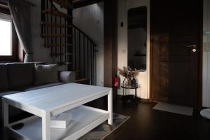 a living room with a white coffee table and a staircase at Supsi Saun in Supsi