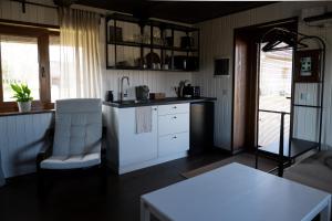 a kitchen with white cabinets and a table and a chair at Supsi Saun in Supsi
