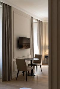 a dining room with a table and chairs and a television at Grand Jardin Hotel in Baku