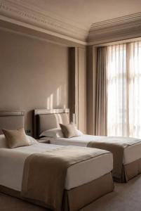 a hotel room with two beds and a window at Grand Jardin Hotel in Baku