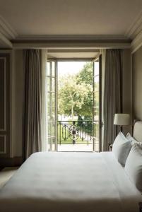 a bedroom with a large bed and a large window at Grand Jardin Hotel in Baku