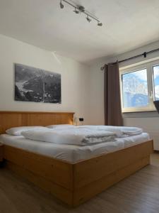 a large bed in a room with a window at Apart Leitner in Lermoos