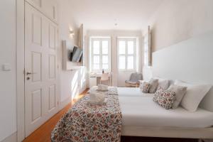 a white room with a bed and a door at Porto Lounge Hostel & Guesthouse by Host Wise in Porto