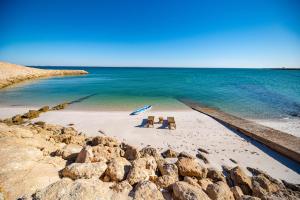 two chairs and an umbrella on a beach at Loft Beachfront Bungalow with Private Beach in Dakhla +4 photos