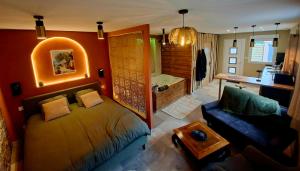 a living room with a bed and a bathroom with a tub at La Casetta refuge méditerranéen et balnéo classé 3 étoiles in Wizernes