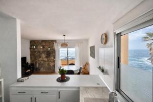 a white kitchen with a view of the ocean at Terraza con vistas al mar Tenerife Norte Mesa del Mar in Tacoronte