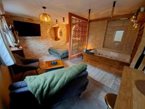 a living room with a couch and a tub at La Casetta refuge méditerranéen et balnéo classé 3 étoiles in Wizernes