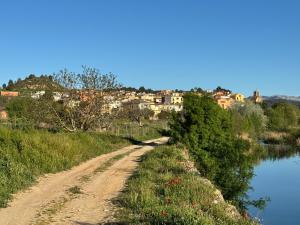 a dirt road next to a body of water at Cal Padrí in Caseras