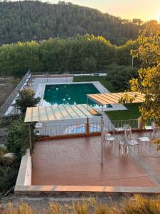an empty swimming pool with a table and chairs at Cal Padrí in Caseras