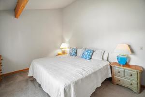 a bedroom with a bed with blue pillows and a night stand at 17 Quelah Condo in Sunriver