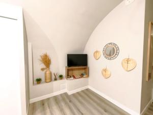 a room with a tv and a wall with a mirror at Mistral Studio in Cassis