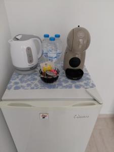 a blender and a coffee maker on top of a refrigerator at Студиа Мансарда Ненови in Pomorie