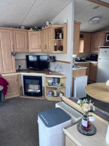 a large kitchen with wooden cabinets and a table at Cocos haven in Ballantrae