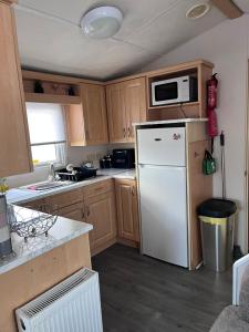 a kitchen with a white refrigerator and a microwave at Cocos haven in Ballantrae +9 photos