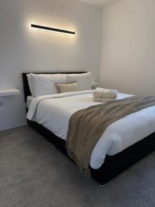 a bedroom with a large bed with white sheets at Coastal Escape in Burtonport