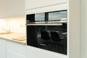 a kitchen with a view of a table with black chairs at Coastal Escape in Burtonport