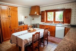 a kitchen with a table with chairs and a sink at Casa Das Flores in Amares