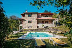 a villa with a swimming pool in front of a house at Casa Das Flores in Amares