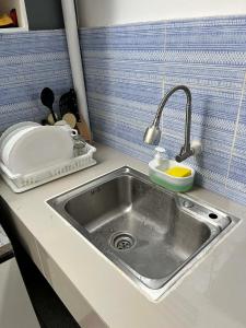 a kitchen counter with a sink and a cutting board at Log Horizon by The Guild Oasis Transient House in Rosario +8 photos
