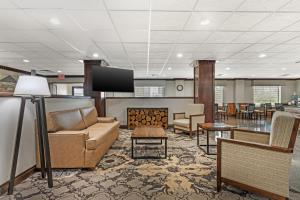 a lobby with a couch and a flat screen tv at Best Western Big Spring Lodge in Neosho