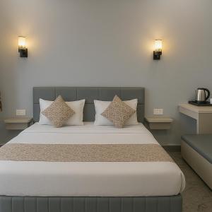 a bedroom with a large bed with two pillows at The Aura - Backpacker Stop in Nainital