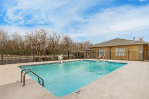 a swimming pool in a yard with a fence at Best Western Big Spring Lodge in Neosho