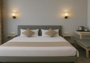 a bedroom with a large bed with two pillows at The Aura - Backpacker Stop in Nainital +18 photos