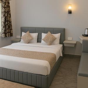 a bedroom with a large bed with white sheets and pillows at The Aura - Backpacker Stop in Nainital