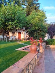 a garden with two vases on a retaining wall at Torre de l'Olivera in Mediona
