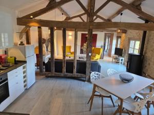 a kitchen and living room with a table and chairs at Le LOFT GASCON in Mauvezin-dʼArmagnac