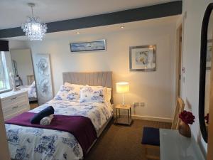 a bedroom with a bed and a chandelier at 2-bed spacious apartment in Falkirk