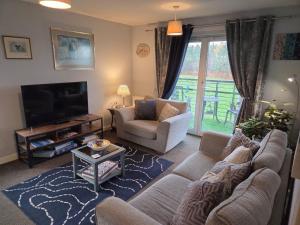 a living room with a couch and a tv at 2-bed spacious apartment in Falkirk