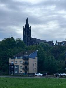 a building with a clock tower and a church at 2-bed spacious apartment in Falkirk