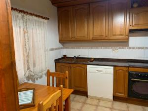 a kitchen with wooden cabinets and a table and a sink at Can Llorach in Sant Jaume d'Enveja +16 photos