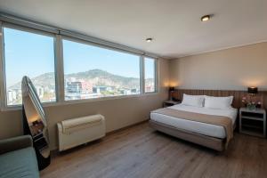 a hotel room with a bed and a large window at Hotel Terrado Lyon in Santiago +32 photos