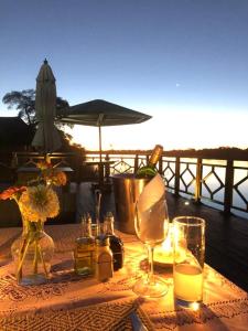 a table with a bottle of wine and glasses at Emms Cubango Ecological Camp in Divundu