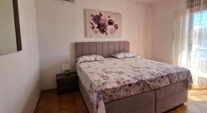 a bedroom with a bed with a purple comforter at Apartments Elena Green Island Escape in Ugljan