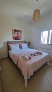 ein Schlafzimmer mit einem großen Bett, auf dem Handtücher liegen in der Unterkunft Sozia in Perdika